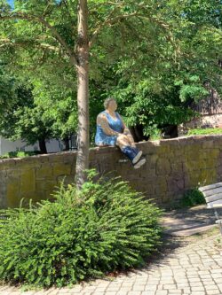 Skulptur einer Frau auf einer Mauer